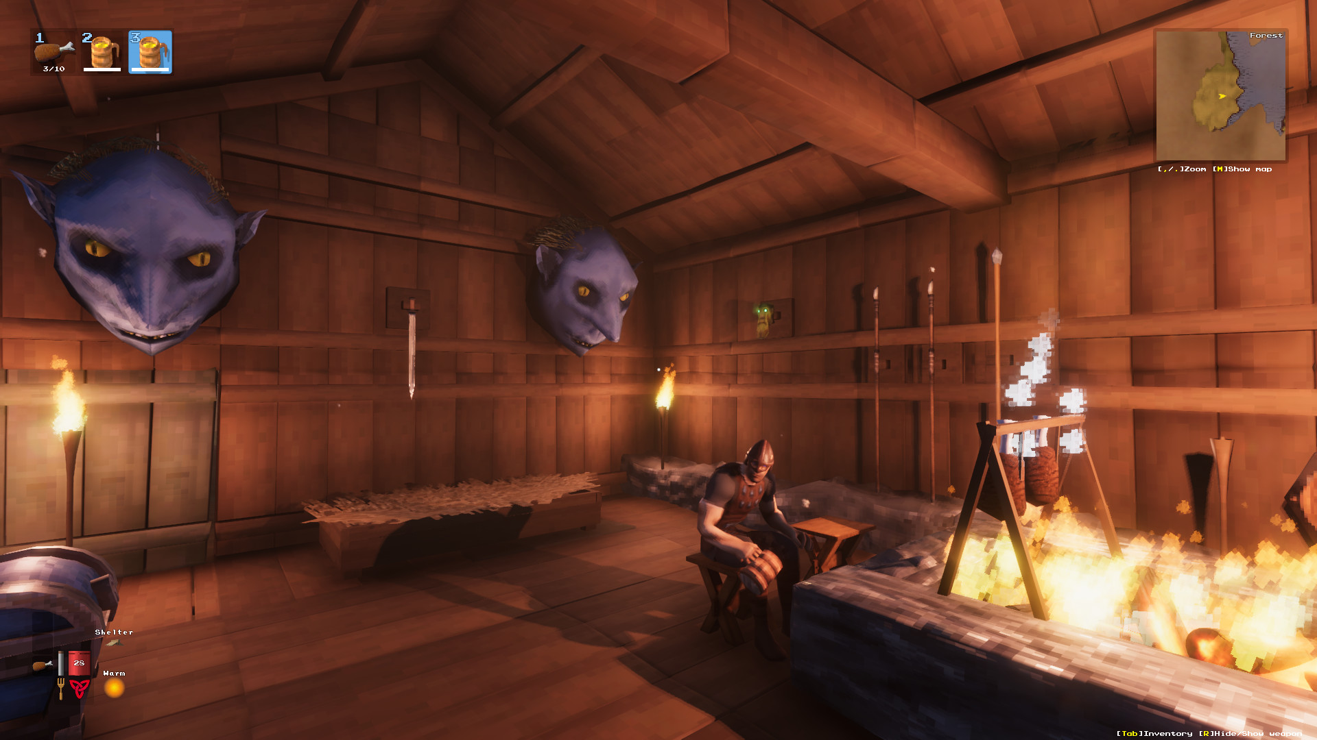 Interior of a Valheim Viking longhouse with boss trophies mounted on the walls.