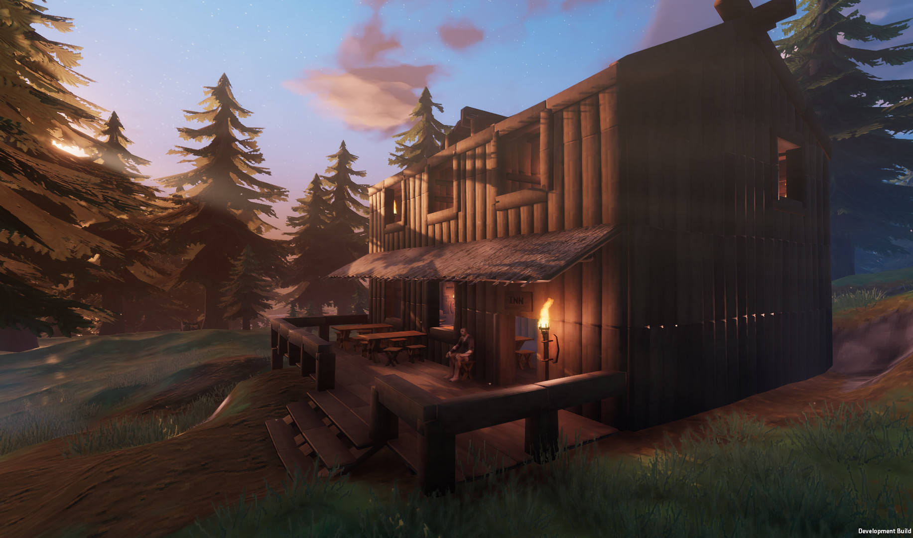 A Viking warrior sitting outside a wooden longhouse in Valheim.